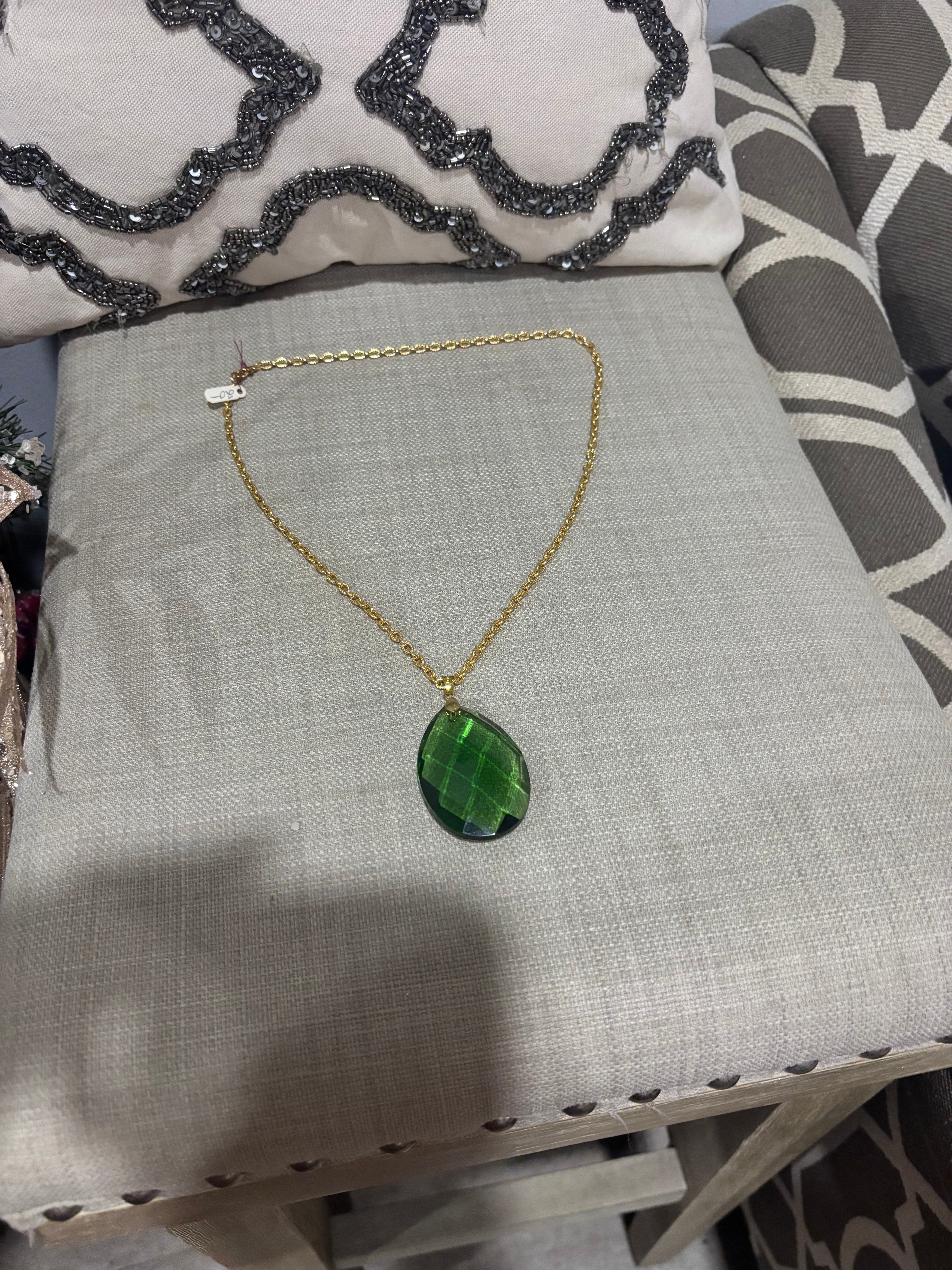 Faceted green teardrop glass pendant set on a gold-tone chain