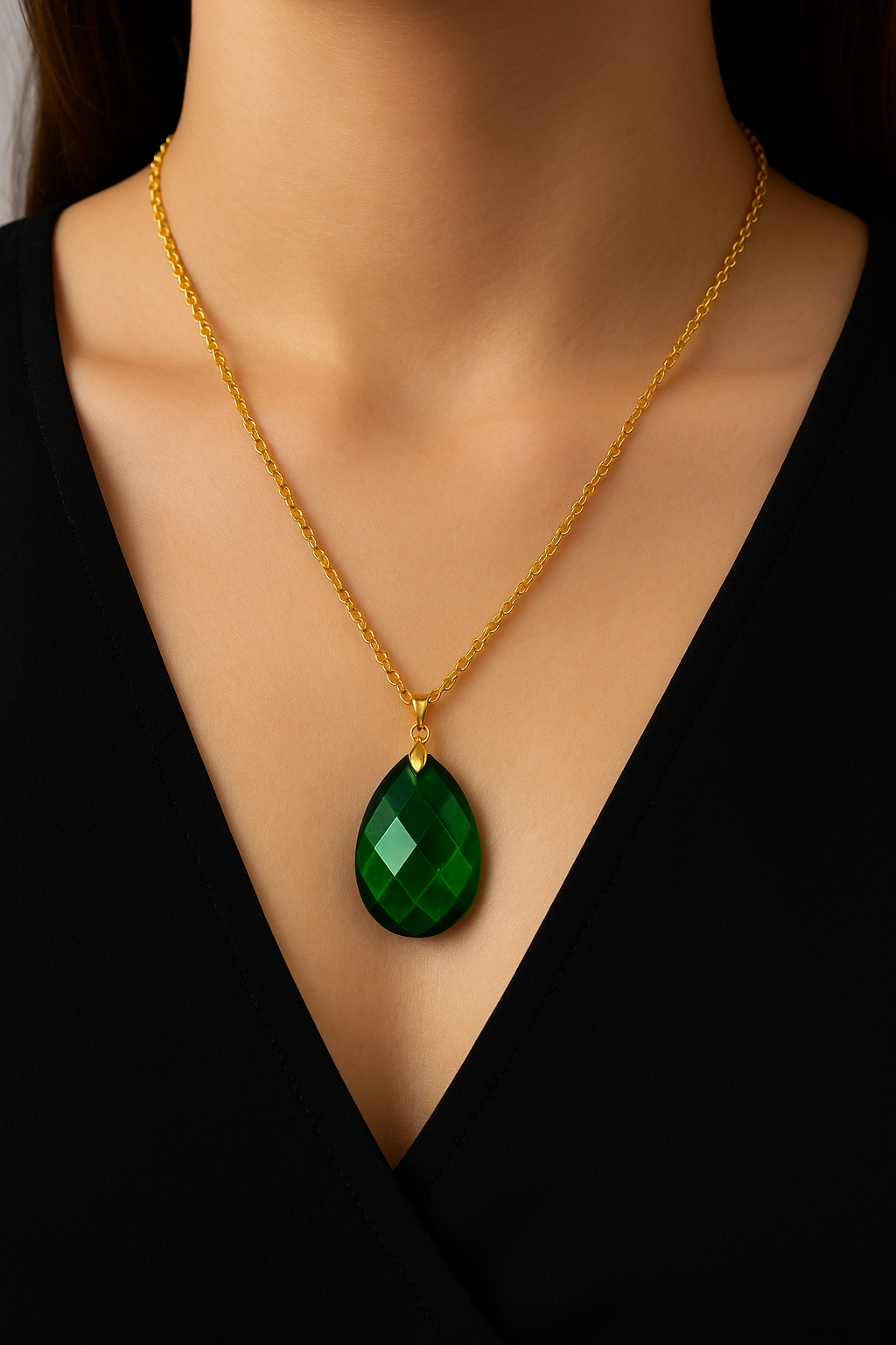 Faceted green teardrop glass pendant set on a gold-tone chain