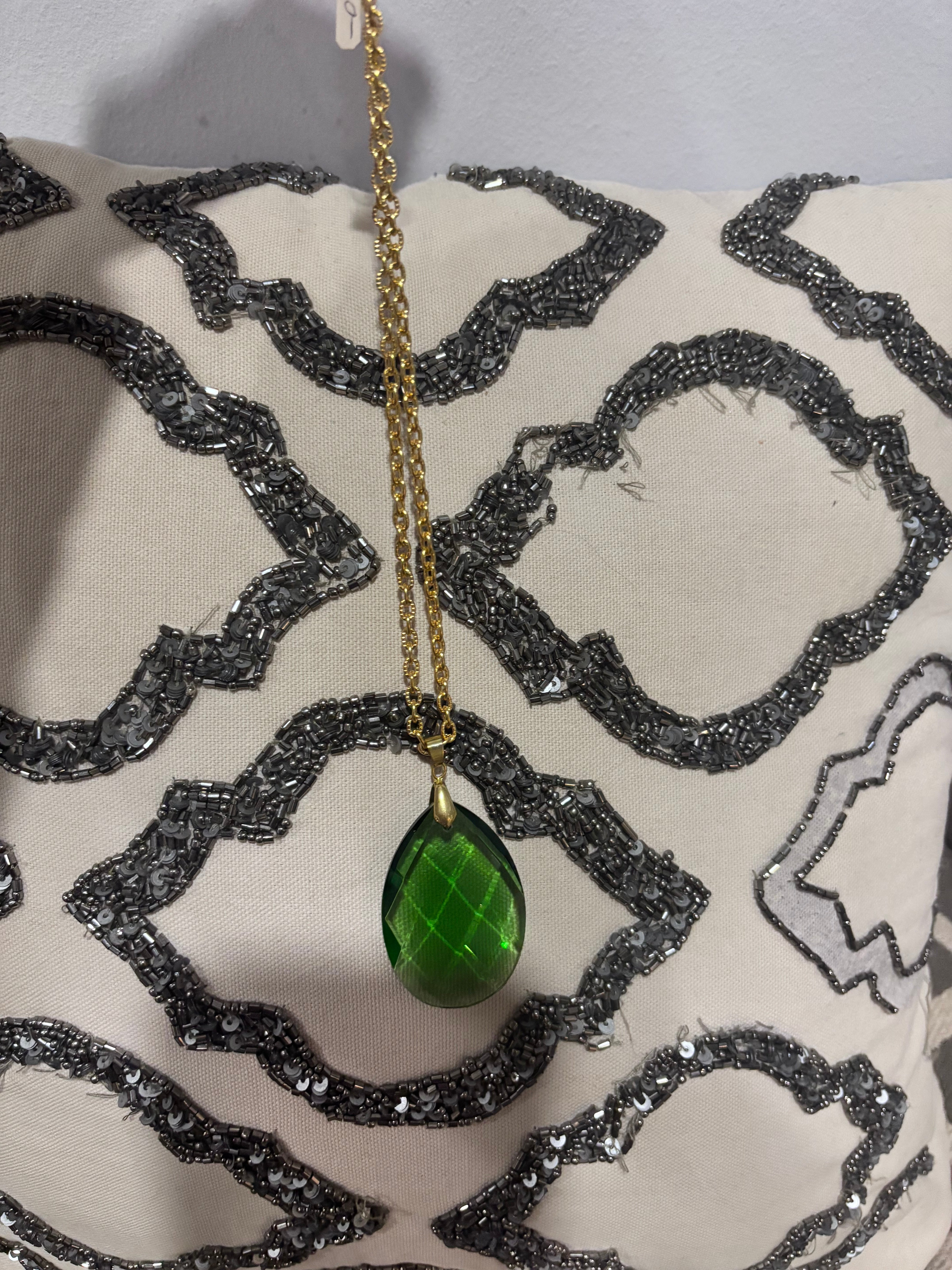 Faceted green teardrop glass pendant set on a gold-tone chain