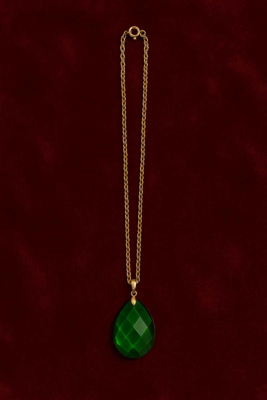 Faceted green teardrop glass pendant set on a gold-tone chain